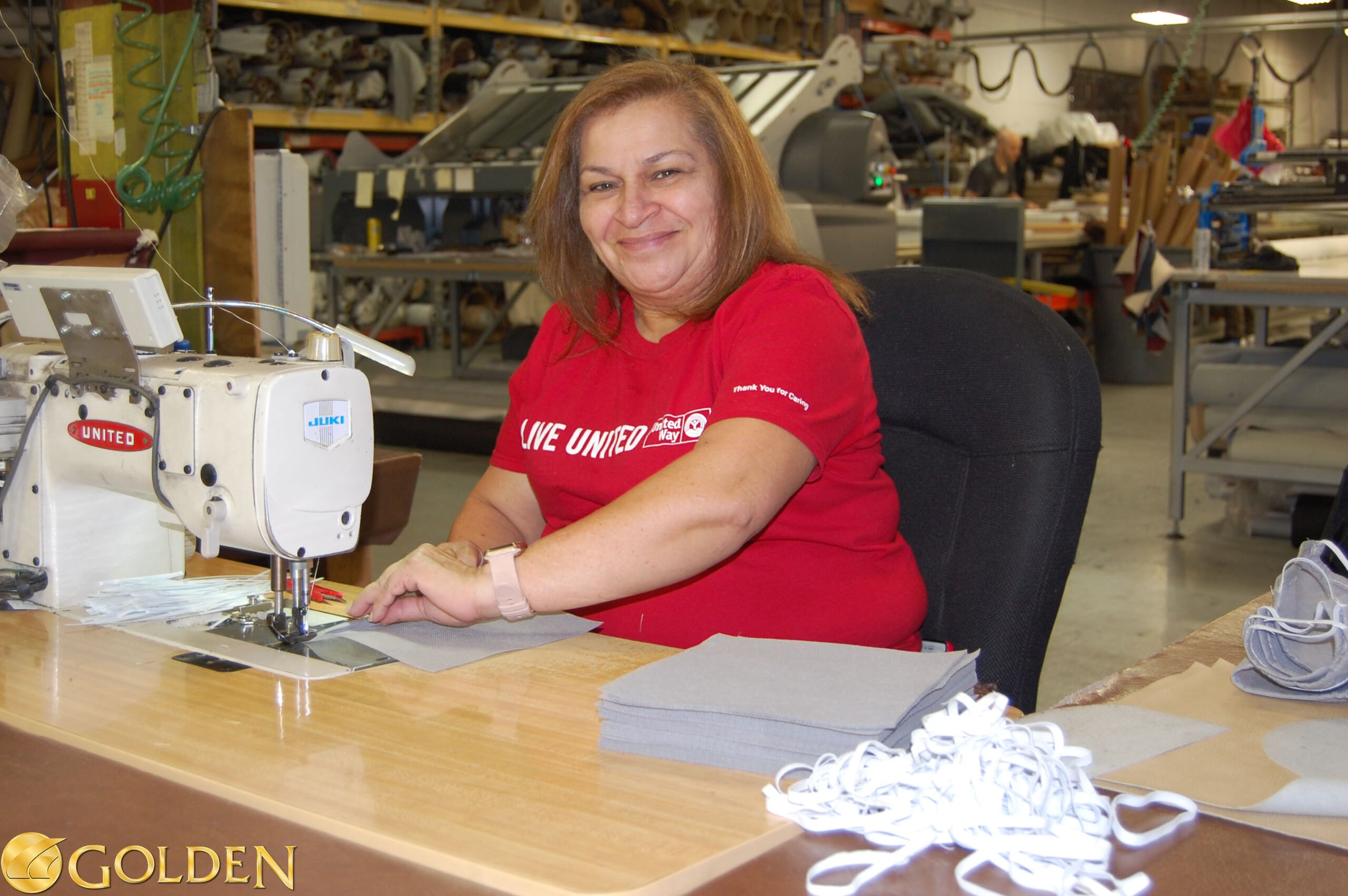 Golden employee sewing masks for Geisinger